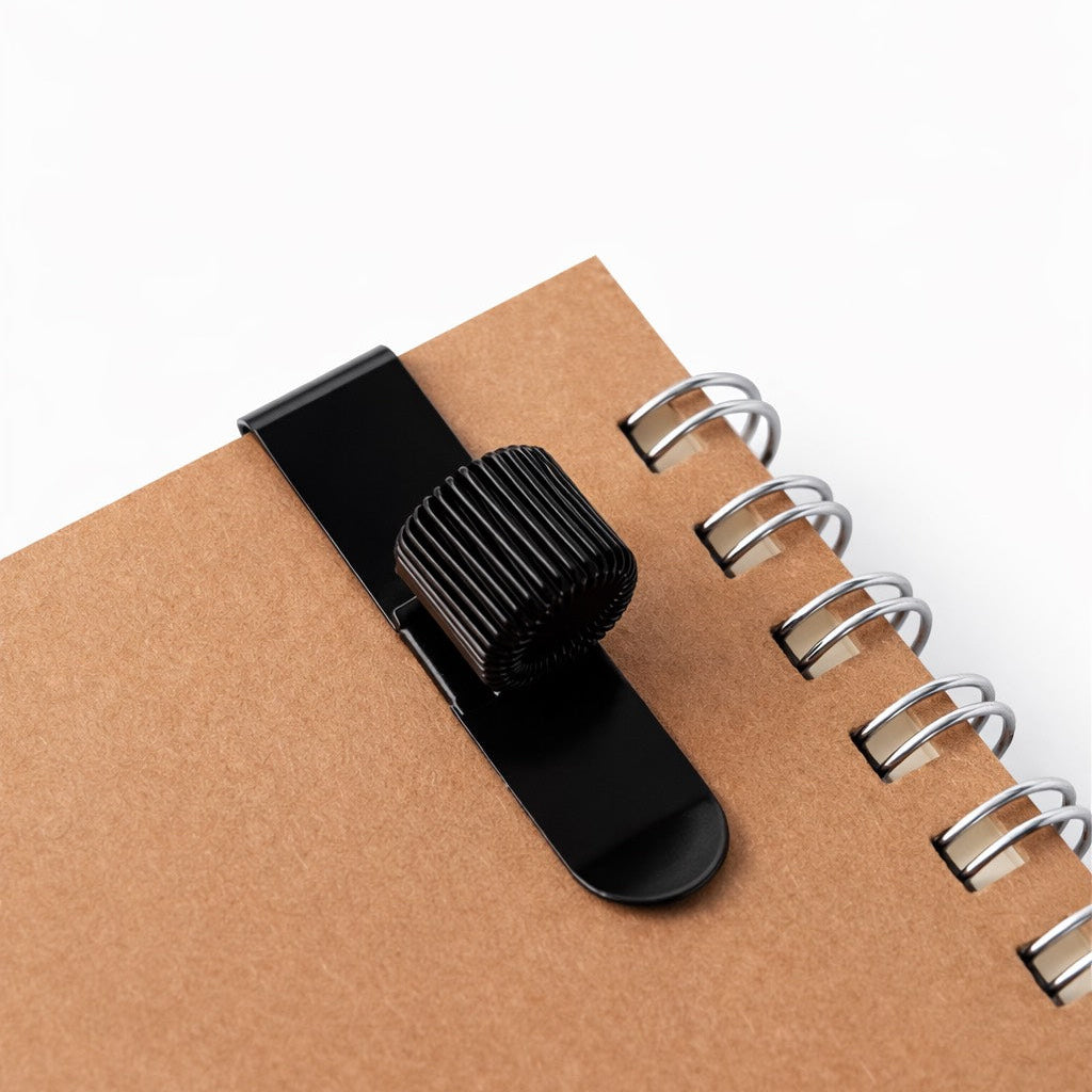 Black pen holder  on a brown notebook with a white background