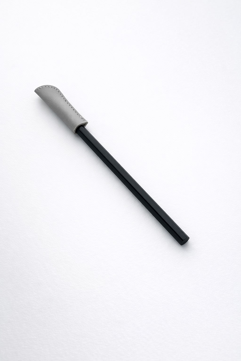 writing pencil with a leather cap on a white background