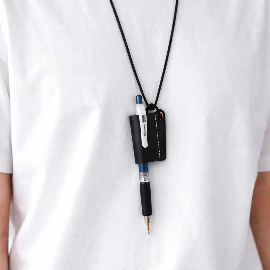 Person wearing a white shirt with a black leather strap for pen holder attached to a necklace.