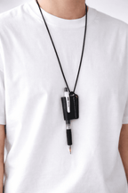 Person wearing a white shirt with a black pen holder strap on a white background