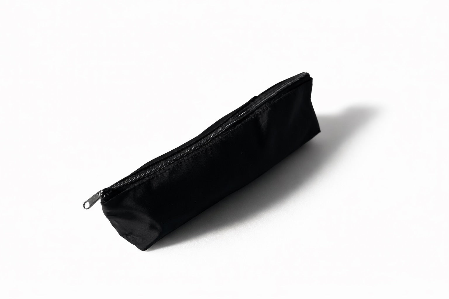 Black rectangular case for a writing set with a zipper on a white background
